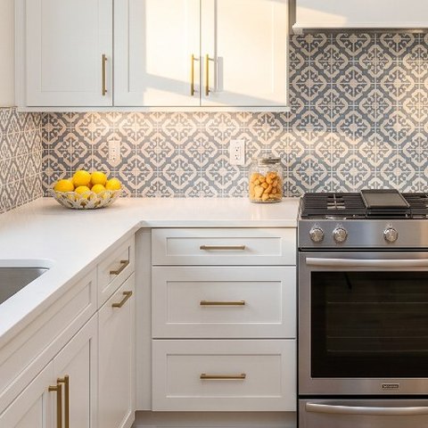 Finished kitchen with white shaker cabinets, white quartz and patterned tile backsplash